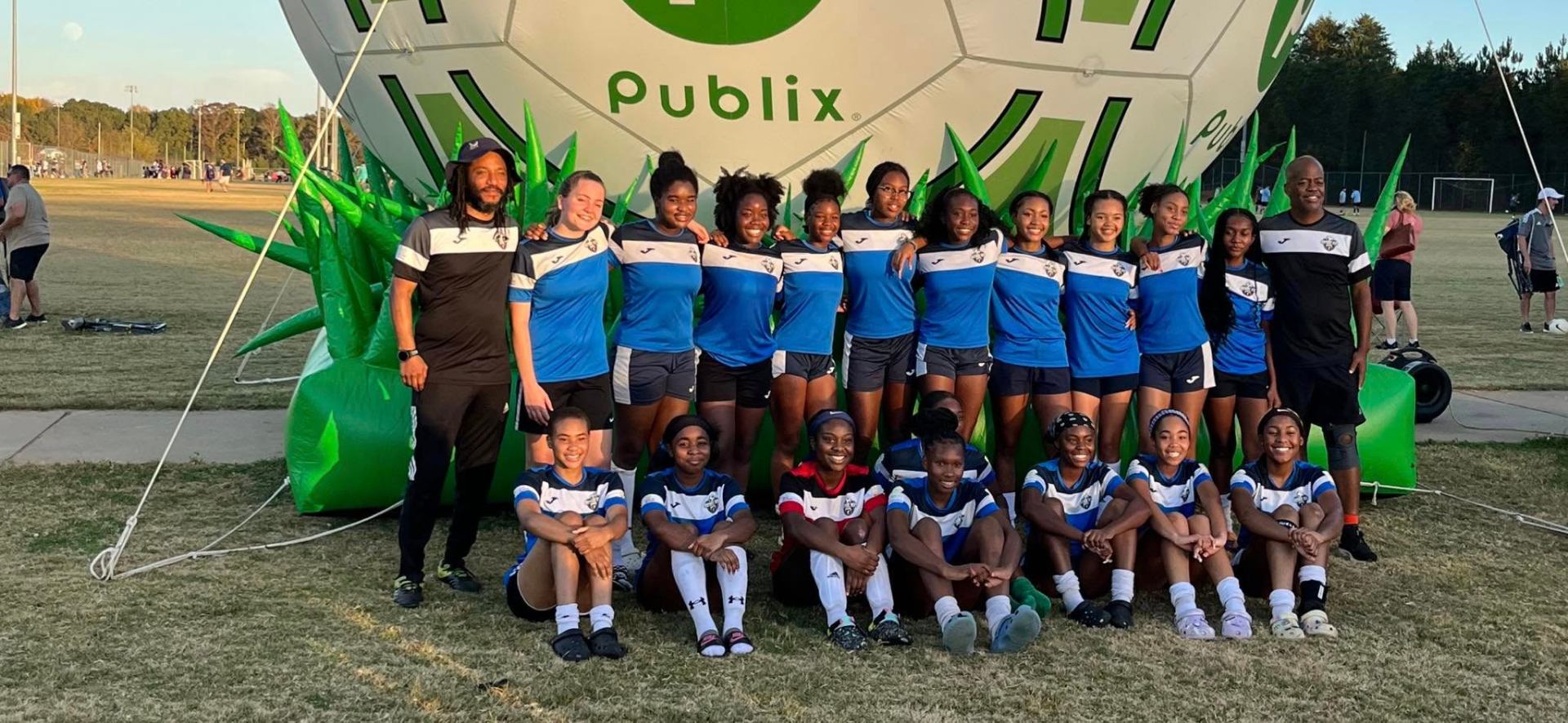 Girls team photo with Publix soccer display