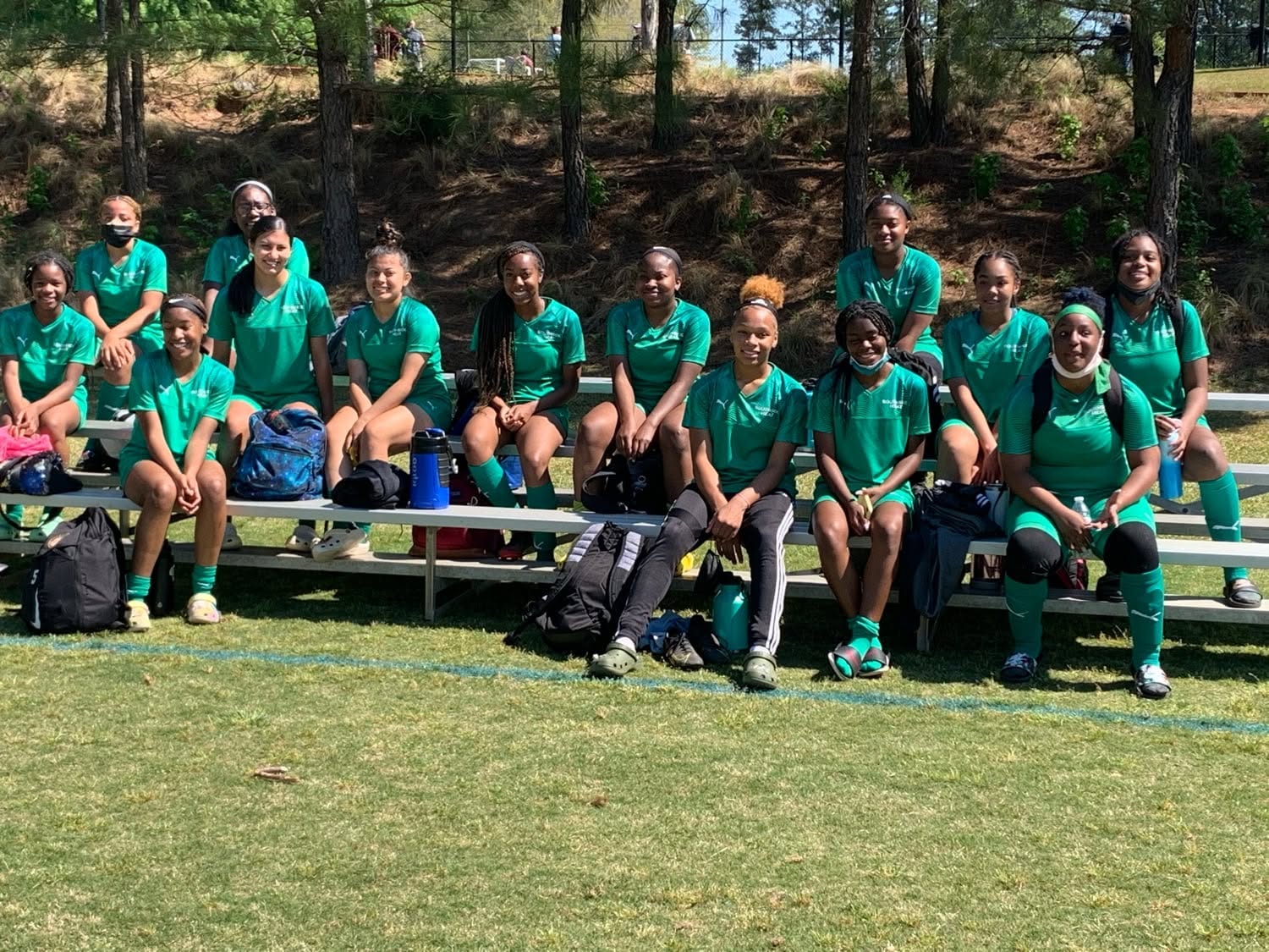 Girls team in green kits on the sidelines